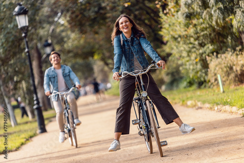Carefree woman cycling with boyfriend at park photo
