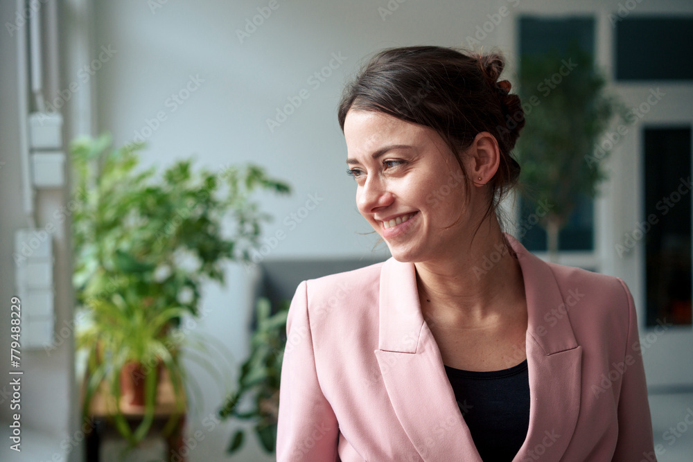 Smiling businesswoman wearing blazer looking away at home office Smiling businesswoman wearing blazer looking away at home office