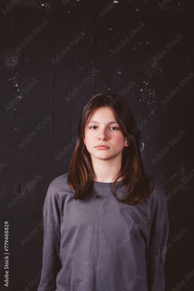 Serious girl with brown hair in front of black background Serious girl with brown hair in front of black background
