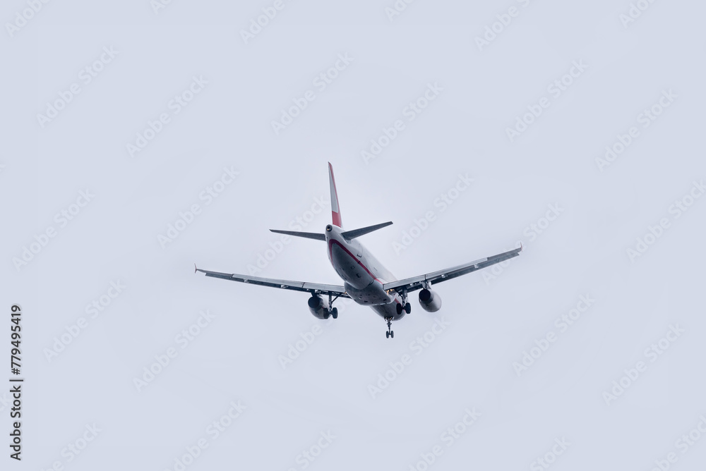 Commercial airplane flying against overcast sky Commercial airplane flying against overcast sky