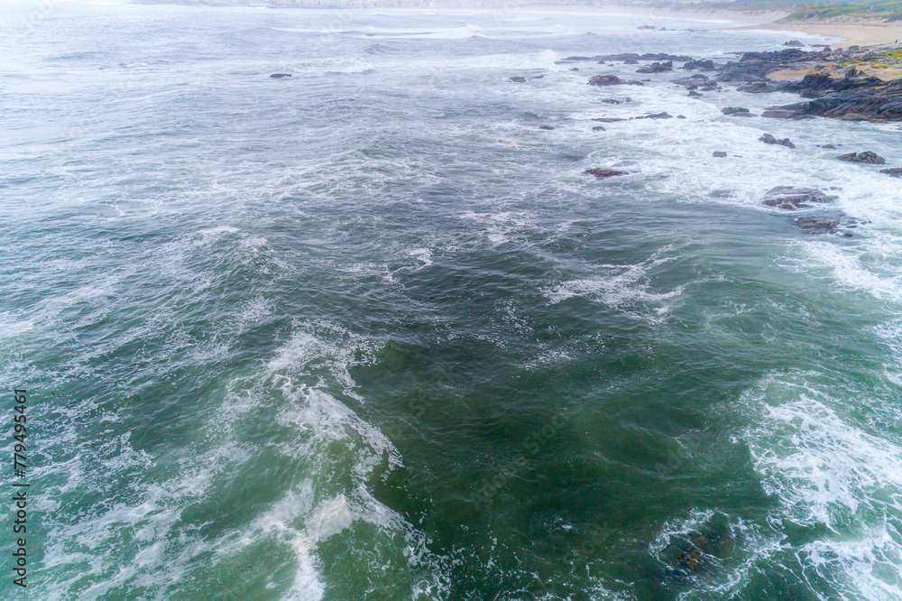 drone view of sea waves crashing on the seashore of the rocky coast with spray and foam, power of the nature concept drone view of sea waves crashing on the seashore of the rocky coast with spray and foam, power of the nature concept