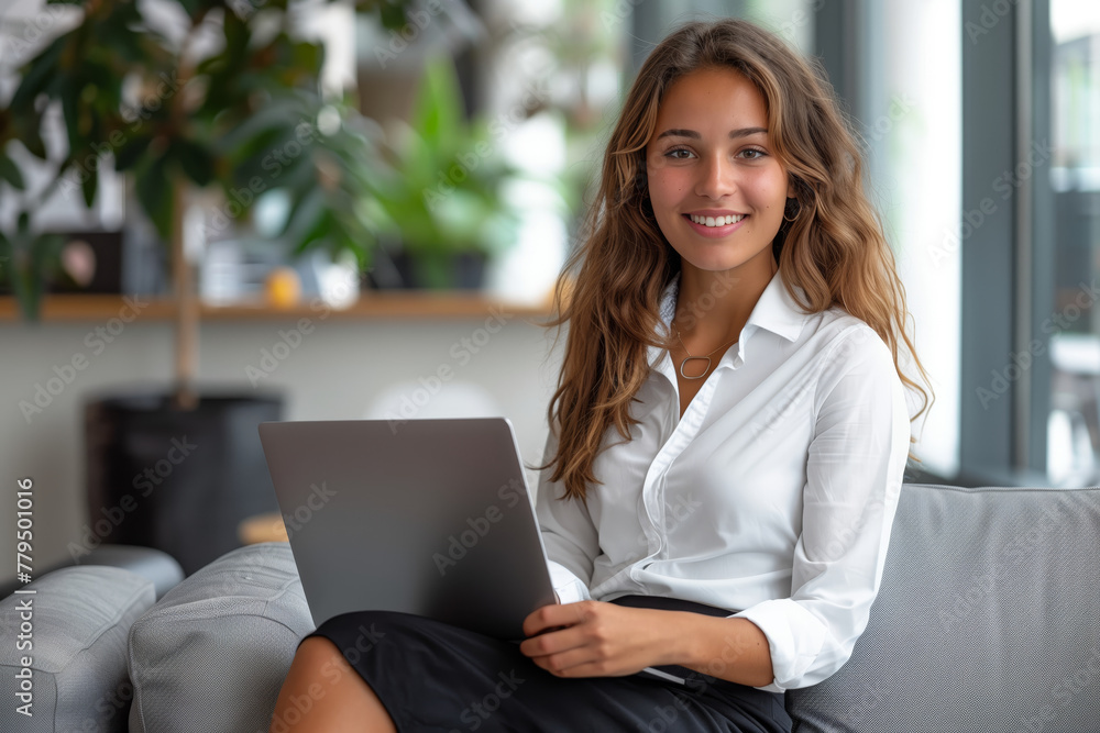Latina woman professional Hispanic is sitting on a couch with a laptop in her lap Latina woman professional Hispanic is sitting on a couch with a laptop in her lap