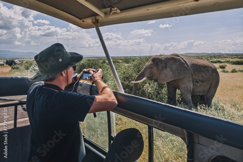 Photography tourist photographs a wild leopard during a safari tour in Kenya and Tanzania