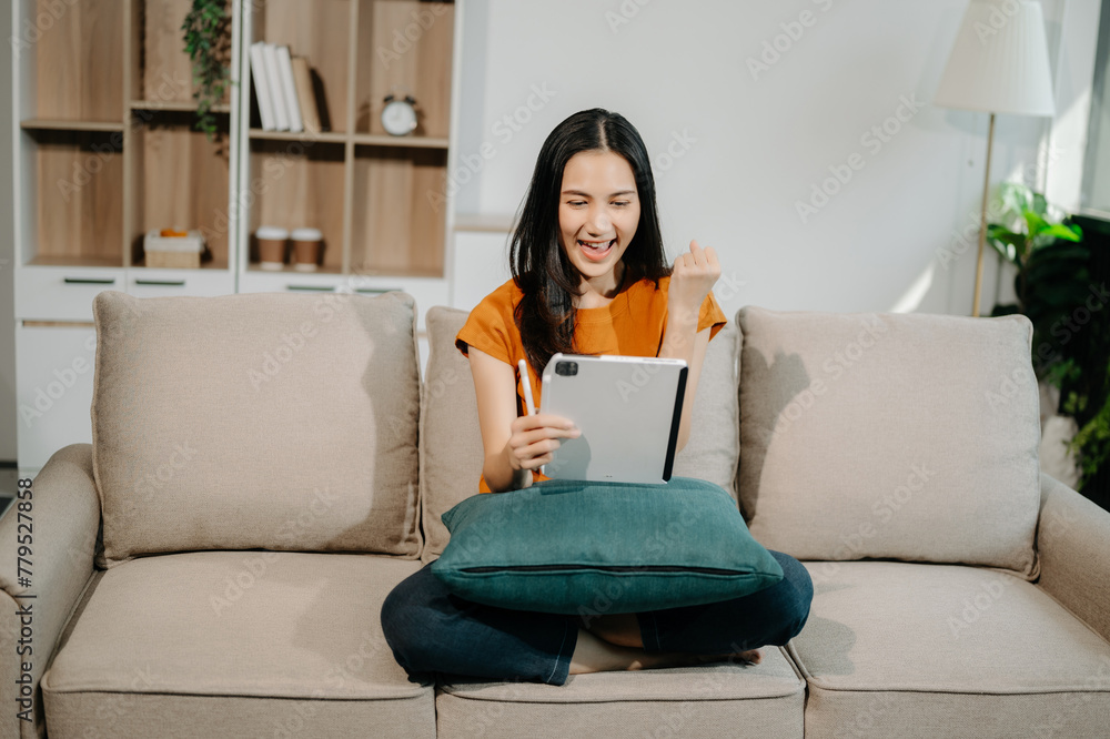 Asian woman using the smartphone and tablet on the sofa at home. Asian woman using the smartphone and tablet on the sofa at home.