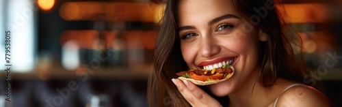 A woman with a smile on her face eating a slice of pizza