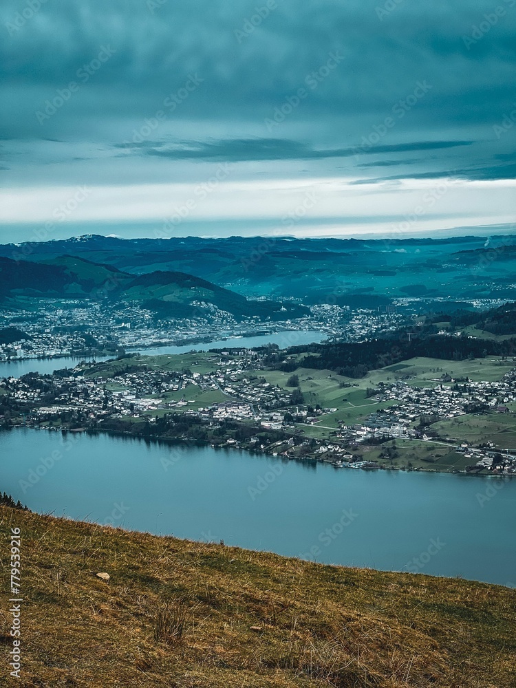 Landscape of Mountain Rigi massif of the Alps by the river with dark blue cloudy sky