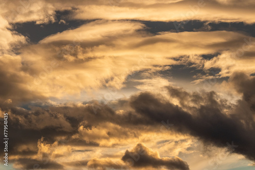 Scenic shot of golden and dark clouds in the sky at sunset