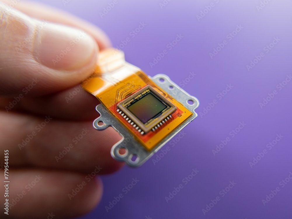 Macro shot of a digital camera Ccd sensor in the hands of a person on a purple background Macro shot of a digital camera Ccd sensor in the hands of a person on a purple background