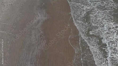 Drone hovering over Galveston Beach with the waves washing up the shore in Texas photo