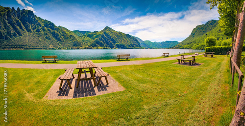 Old wooden table and sits on the shore of Idro lake. Attractive spring scene of Anfo comune in the Brescia region, northern Italy, Europe. Beauty of countryside concept background. photo