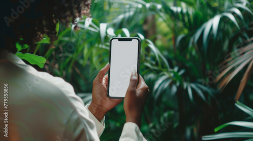 Woman holding a smartphone with a blank white screen, close-up view - smartphone mockup, woman holding phone.