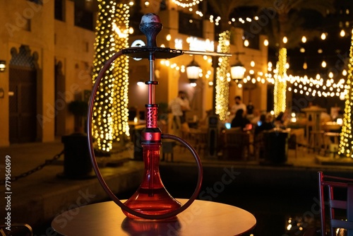 Black and red nargile on a cafe table at night photo