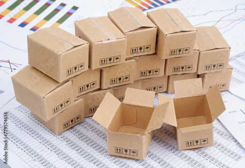 Carton boxes on financial documents  charts and graphs. Cargo and post concept.