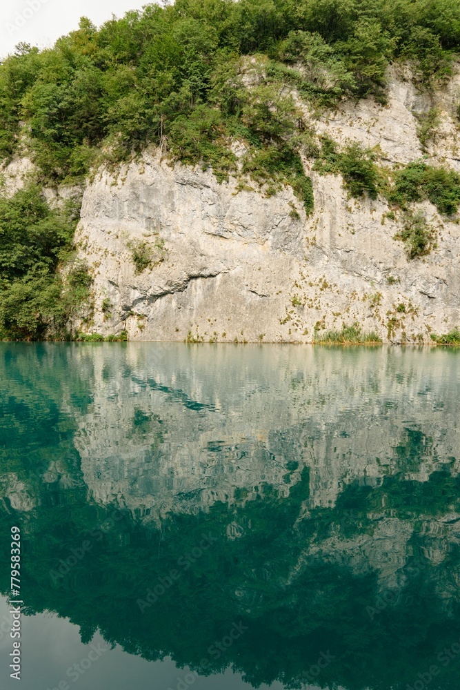 Beautiful vertical shot of bright green trees covering mountains at Plitvice Lakes National Park Beautiful vertical shot of bright green trees covering mountains at Plitvice Lakes National Park