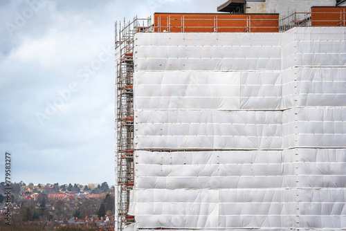 Flame retardant scaffold sheeting wrapped apartments building during insulation in england uk photo