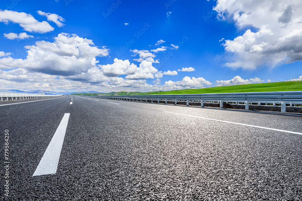 Naklejka premium Asphalt highway road and green meadow with mountain nature landscape under blue sky