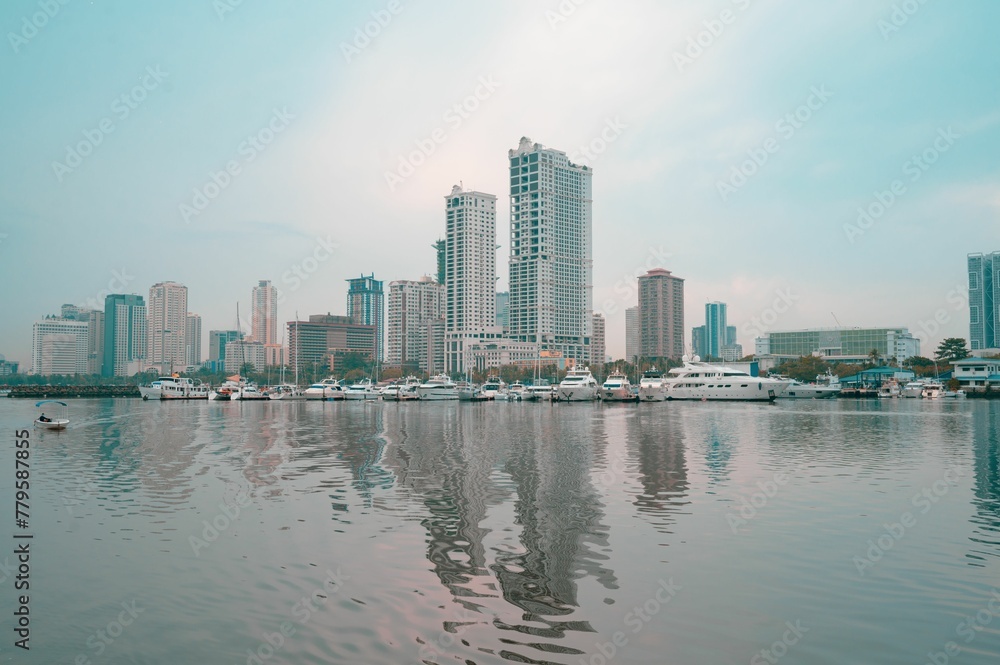 Obraz premium Calm waters of the sea with the buildings of Manila City of the Philippines in the background