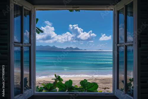 view out a window of the beach and ocean with mountains in the distance