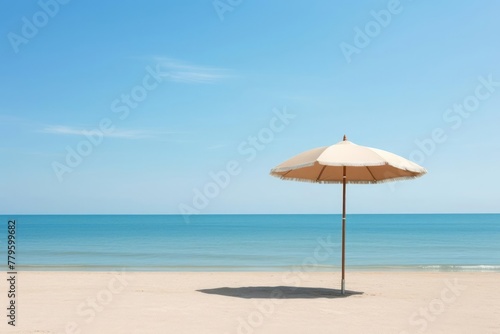 Oceanfront relaxation, showcasing a simple beach umbrella planted firmly in the sand. The tranquil ocean stretches to the horizon under a clear sky, evoking a sense of calm and tranquility.