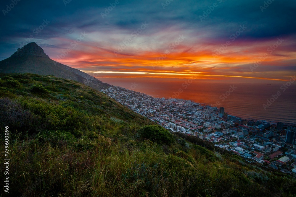 Gorgeous view of a mountainside town in Africa overlooking the calm sea at sunset