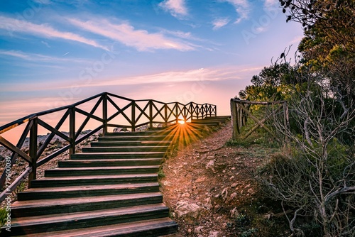 Fototapeta Naklejka Na Ścianę i Meble -  Scenic view of wooden stairs leading to the beach during sunrise