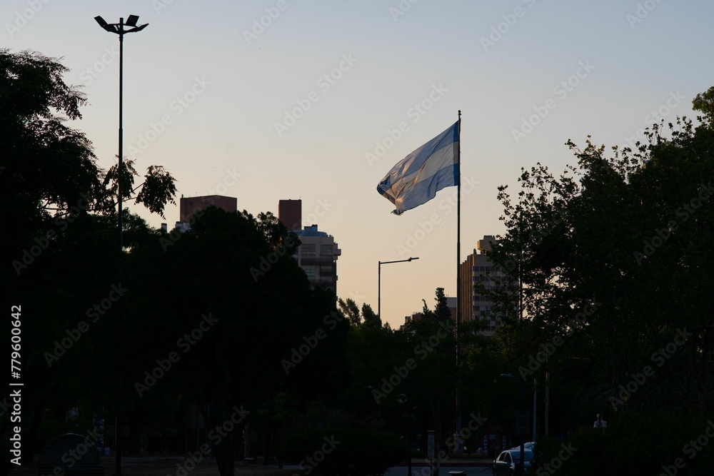 National flag of Argentina on the pole waving in the wind against a blue sky