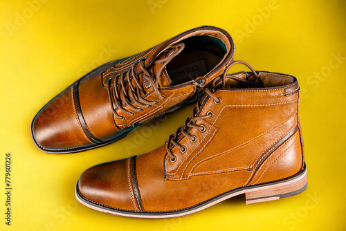 A pair of premium calfskin boots on a yellow background. Horizontal shot.