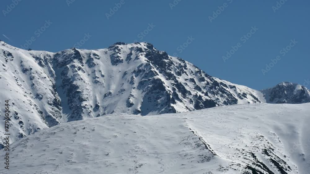 Tatra Mountains with snowy peaks in Poland against the daytime blue sky