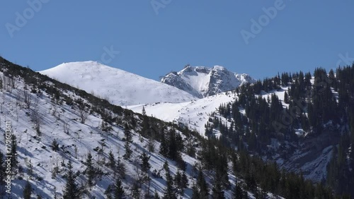 Tatra Mountains with snowy peaks in Poland against the daytime blue sky