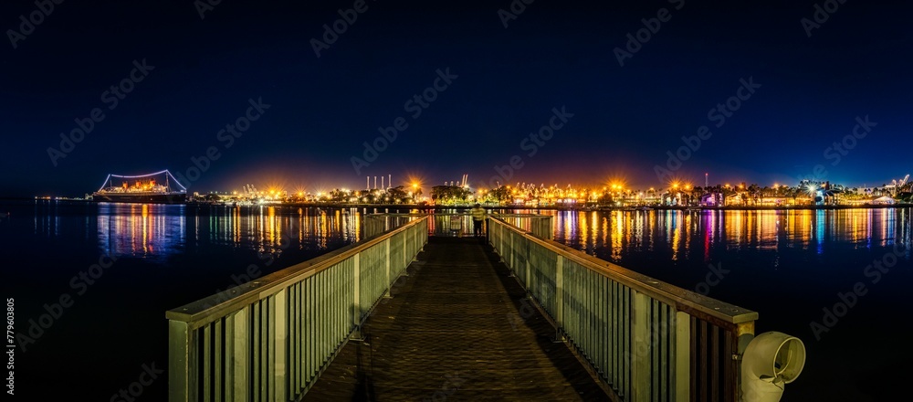Night view of Shoreline Village pier with illuminated buildings in the background in Long Beach