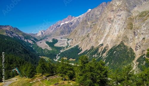 Aerial shot of the rocky mountains and green trees in the valley of Aosta in Italy