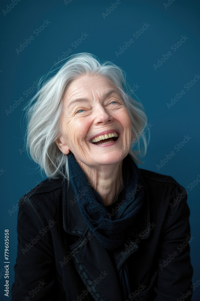 An older woman happily smiles while wearing a black jacket An older woman happily smiles while wearing a black jacket