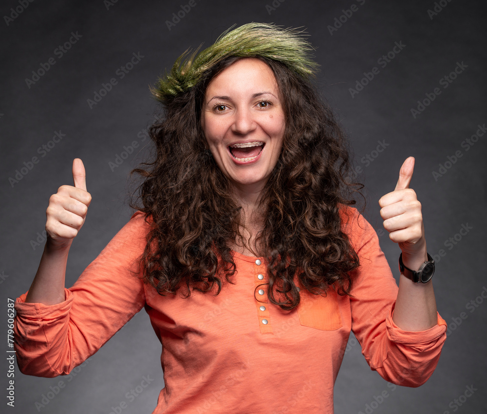 Smiling happy woman with wreath on head posing in studio