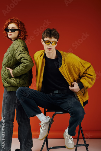good looking fashionable man in stylish sunglasses sitting on chair next to his loving girlfriend © LIGHTFIELD STUDIOS