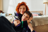 stylish cheerful woman with red hair spending time with her boyfriend and hugging him lovingly
