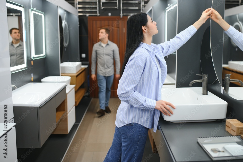Positive couple choosing wash basin in bathroom furniture shop Positive couple choosing wash basin in bathroom furniture shop
