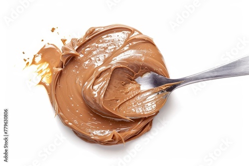 Overhead shot of chocolate caramel cream being mixed into cake batter with a spoon isolated on white background