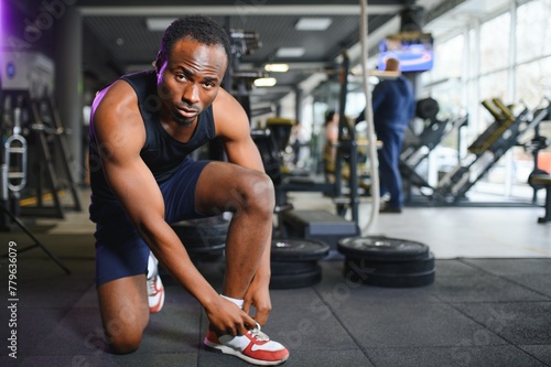 African Man tying shoelaces at sneaker in the gym