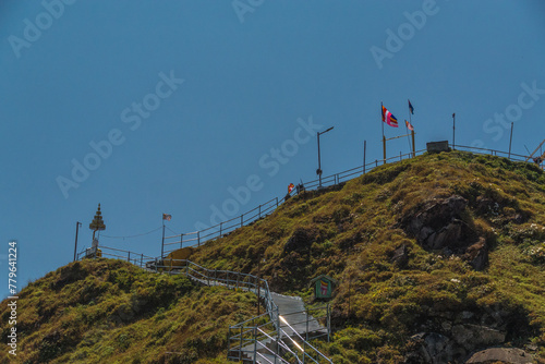 A hill with a fence and a sign on it