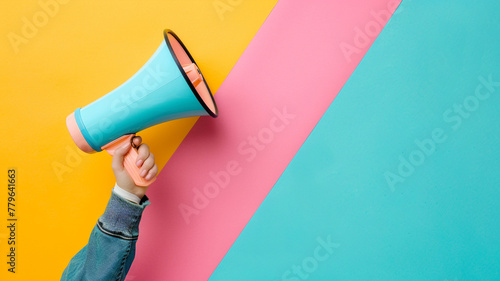 Hand holding a megaphone on a pastel background