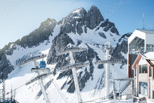 Blue cable car with nature view Jade Dragon Snow Mountain with soft sunlight and clear sky background in morning, Shangri-La City or Xiang Ge Le La at Yunnan, China