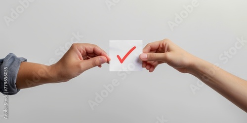 Two people holding a piece of paper with a red check mark on it. The check mark is a symbol of approval or agreement. Concept of collaboration and teamwork