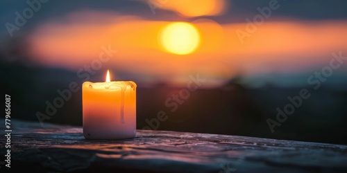 A candle is lit on a ledge at sunset. The candle is surrounded by a warm glow, and the light from the candle casts a soft, romantic atmosphere. The scene is peaceful and calming