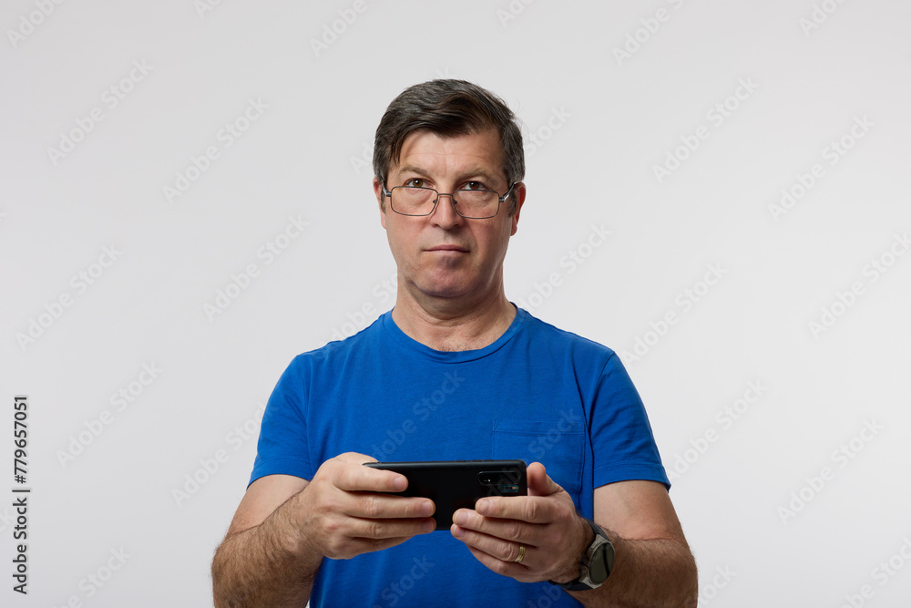 portrait of an old man with eyeglasses and a smartphone in his hand. portrait of an old man with eyeglasses and a smartphone in his hand.