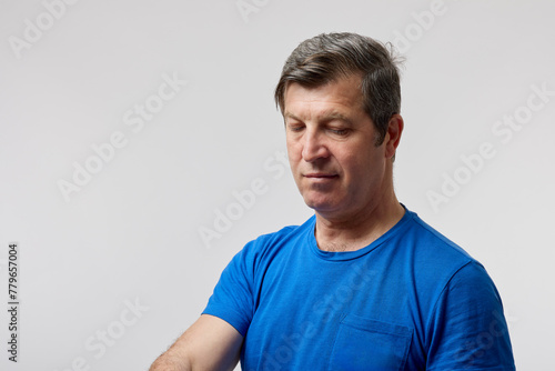 portrait of an isolated middle aged man looking down.