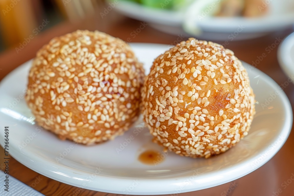 Two sesame balls at a Chinese eatery on a plate