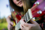 Close-up of a girl's hands playing the guitar.