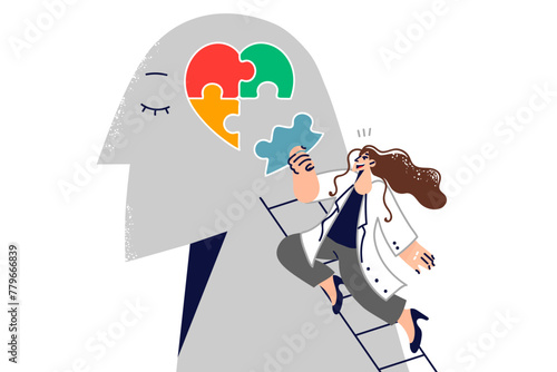 Woman psychotherapist helps restore psychological health of patient by assembling heart from puzzle