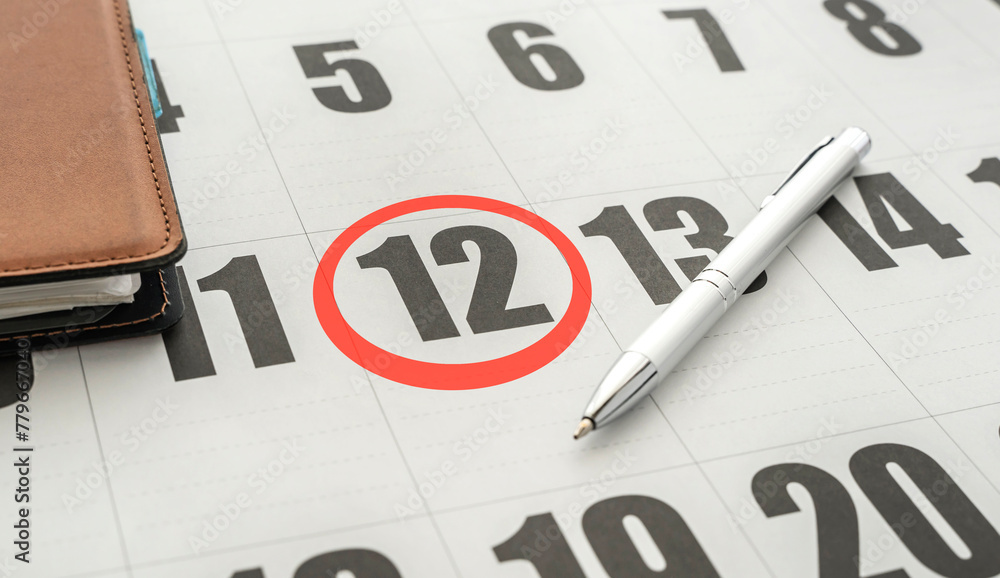 calendar on the table. 12th of the month marked with a red circle calendar on the table. 12th of the month marked with a red circle