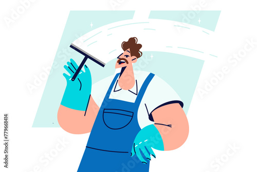 Man window cleaner cleans glass, polishing surface and removing traces of streaks and stains